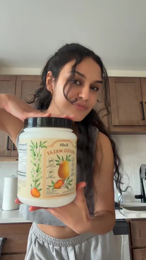 Customer holding a Mango Malai whey tub in her kitchen