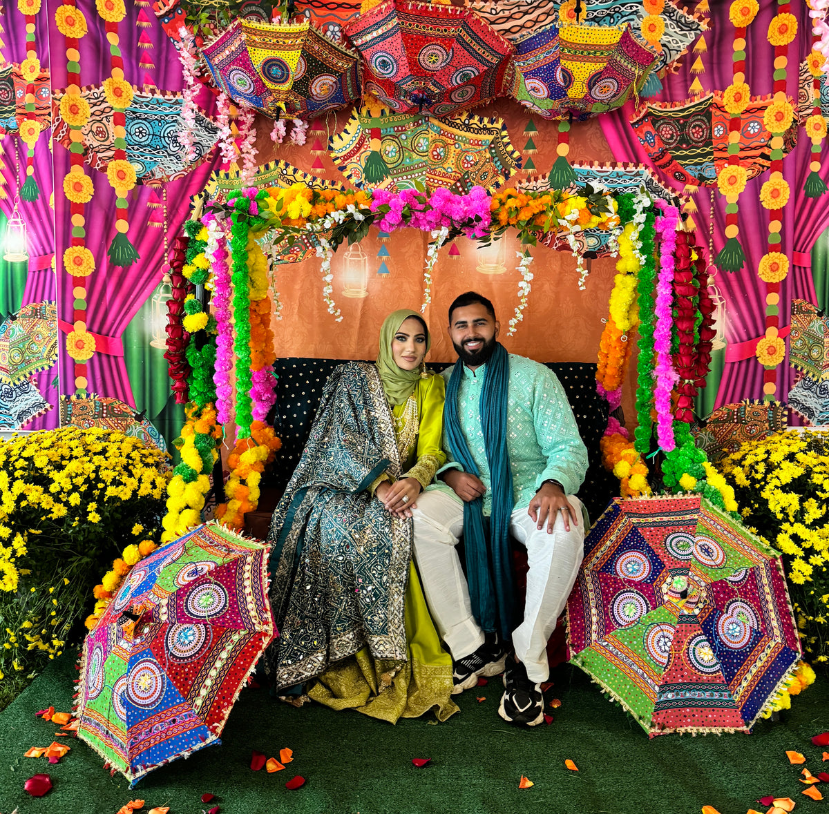 Kulfé founders seated at a colorful South Asian celebration